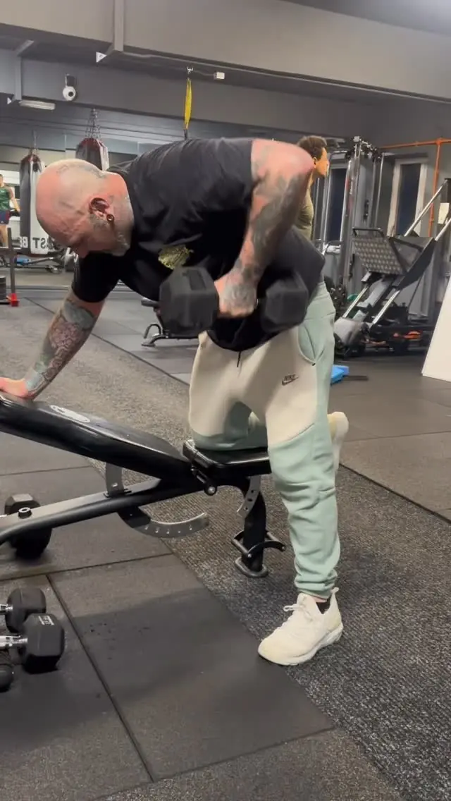 A member doing single-arm dumbbell rows on a bench