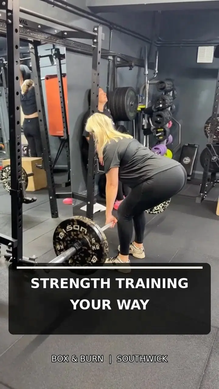 A member lifting a barbell off the floor by the racks, captioned 'Strength training your way'